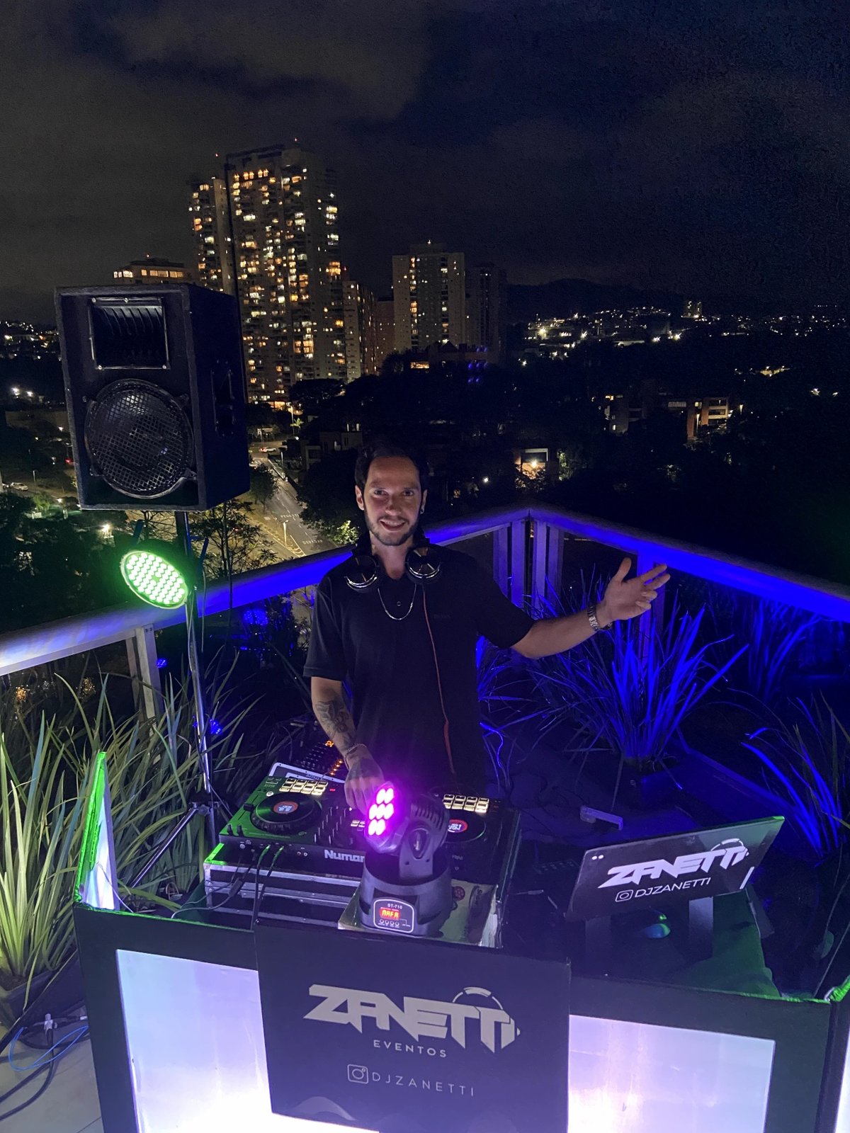 DJ Zanetti em performance noturna com vista da cidade